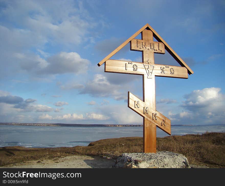 Winter. Wooden christian cross on the coast of the river. Winter. Wooden christian cross on the coast of the river.