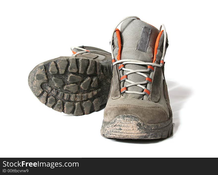 Dirty trekking shoes isolated on white background