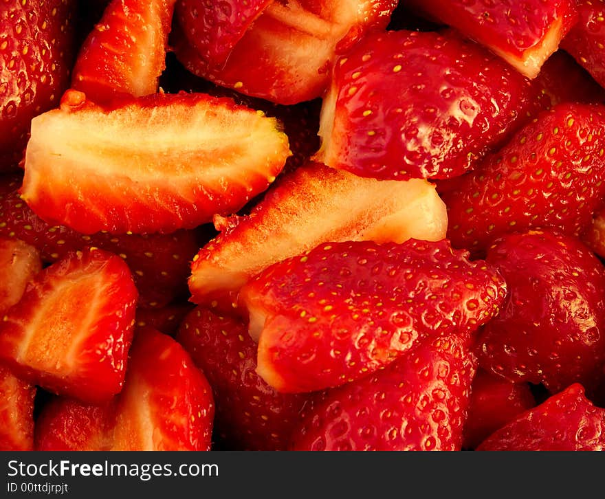 A background of red cut strawberries. A background of red cut strawberries