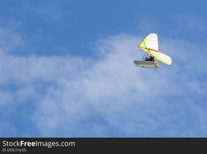 Hang-glider in a blue sky with two men onboard