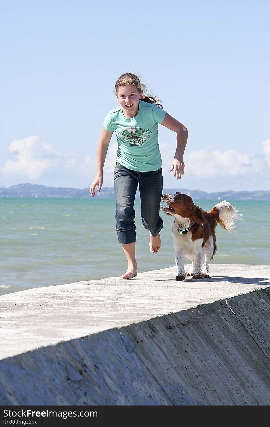 Teenage girl running with her dog at the beach. Teenage girl running with her dog at the beach