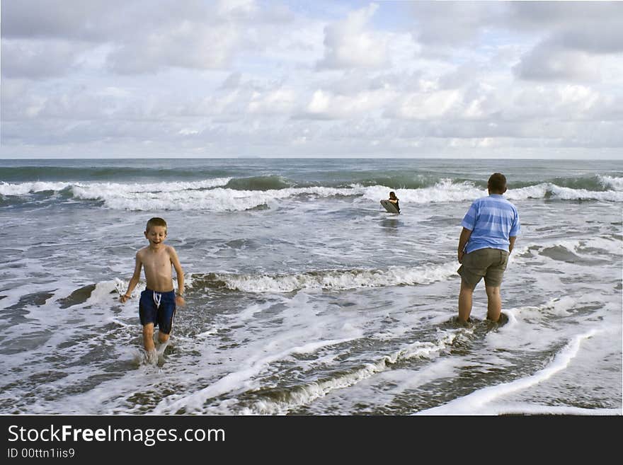 Father with children in the surf. Father with children in the surf