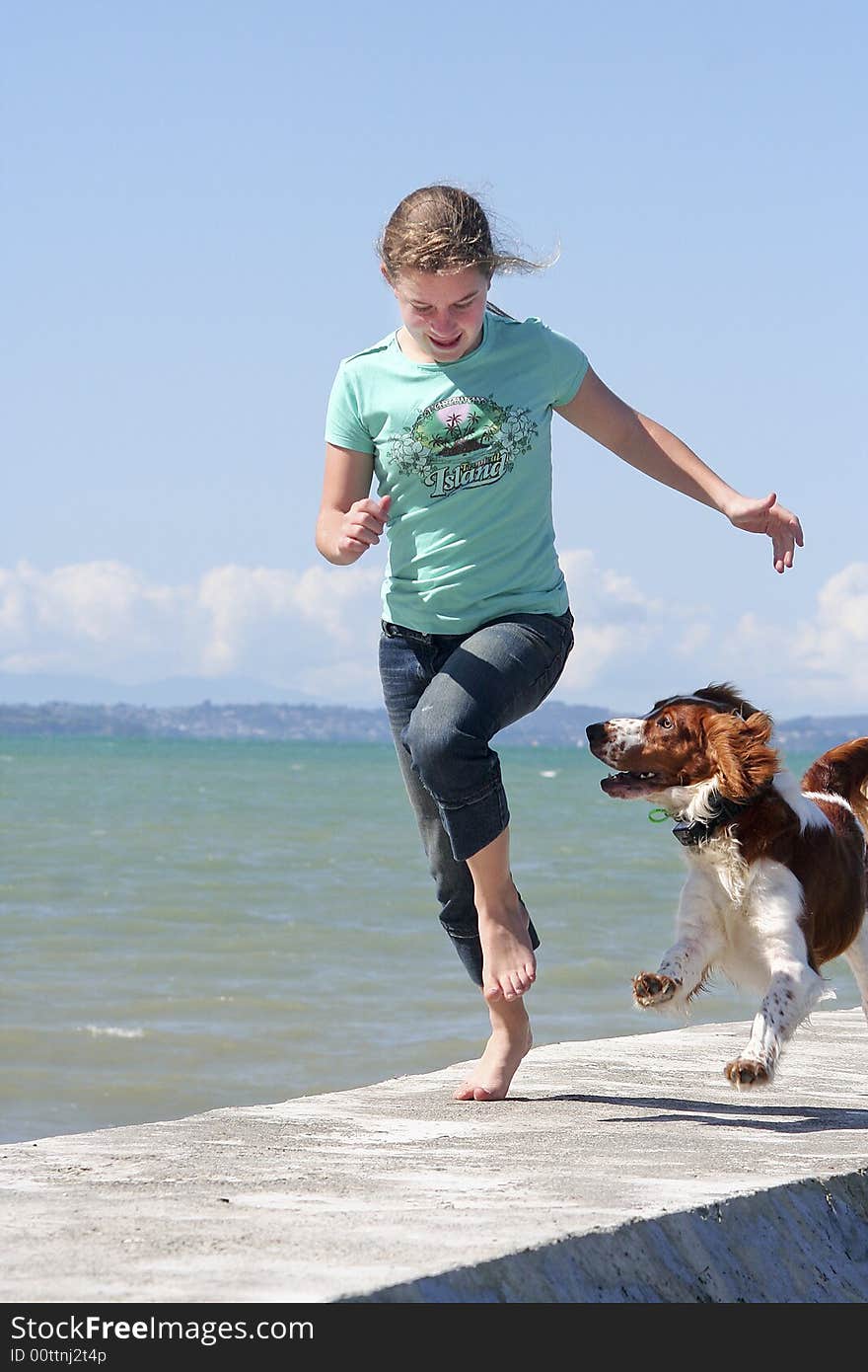 Teenage girl running with her dog at the beach. Teenage girl running with her dog at the beach