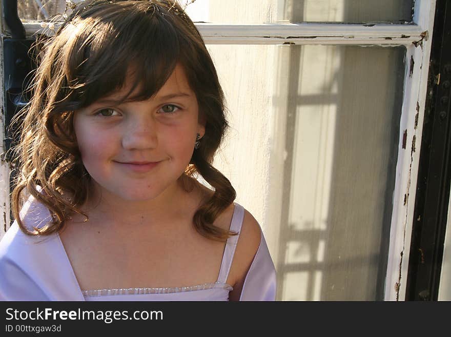 Young flower girl in violet colored dress with fancy hair and earrings. Young flower girl in violet colored dress with fancy hair and earrings.