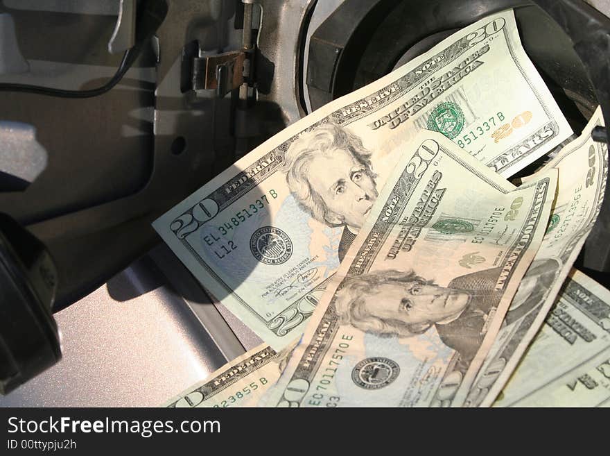 Twenty dollar bills falling into gas tank. Twenty dollar bills falling into gas tank.