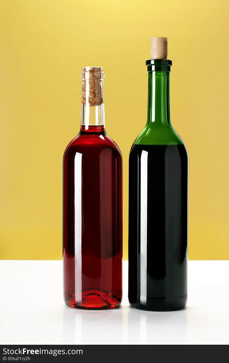 Two bottles of wine on yellow background