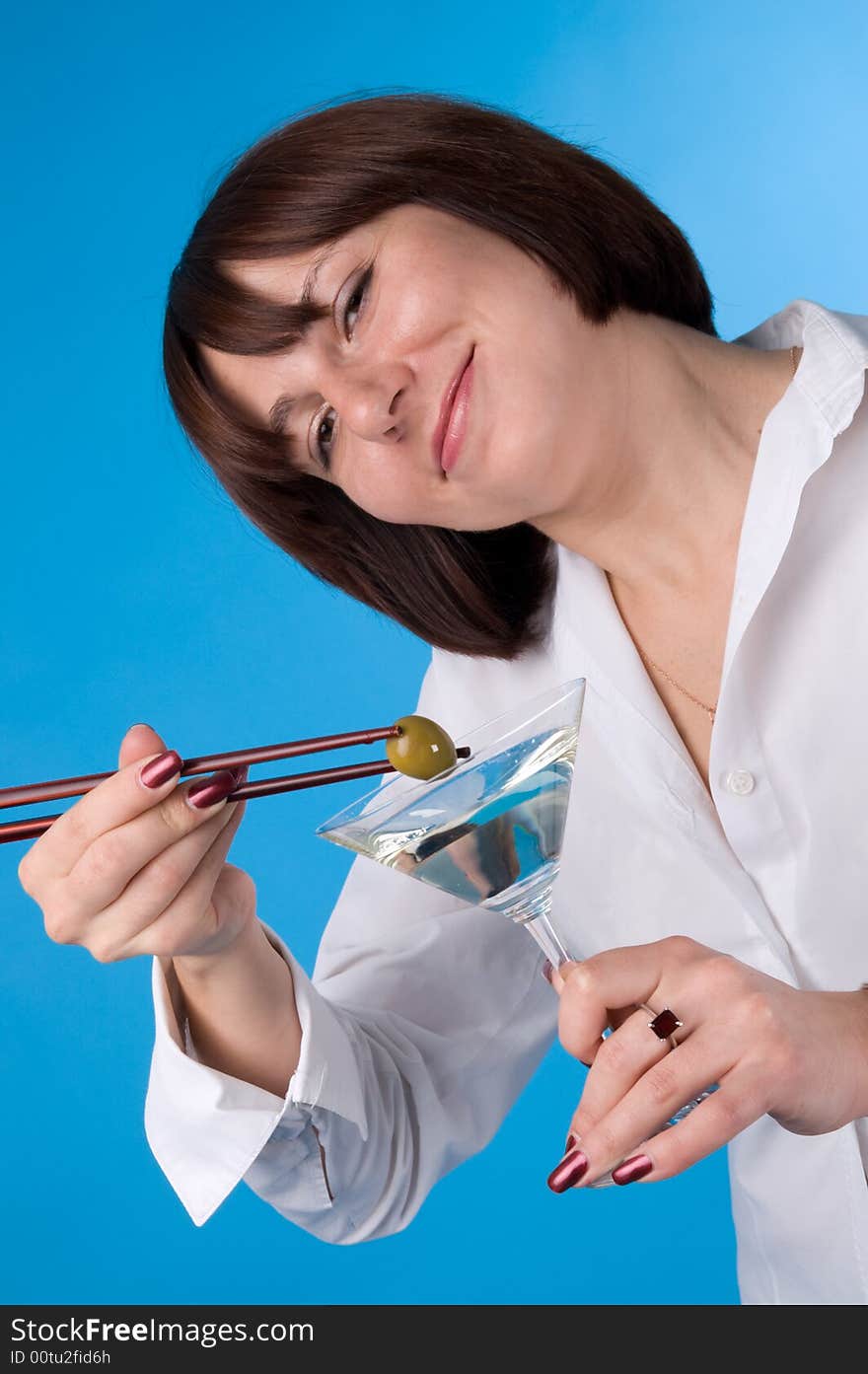 The woman in a white shirt with a glass of martini. The woman in a white shirt with a glass of martini