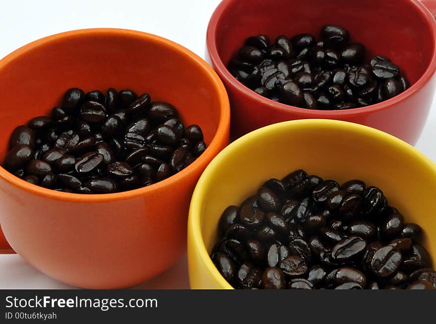 Three colorful cups full with coffee beans. Three colorful cups full with coffee beans