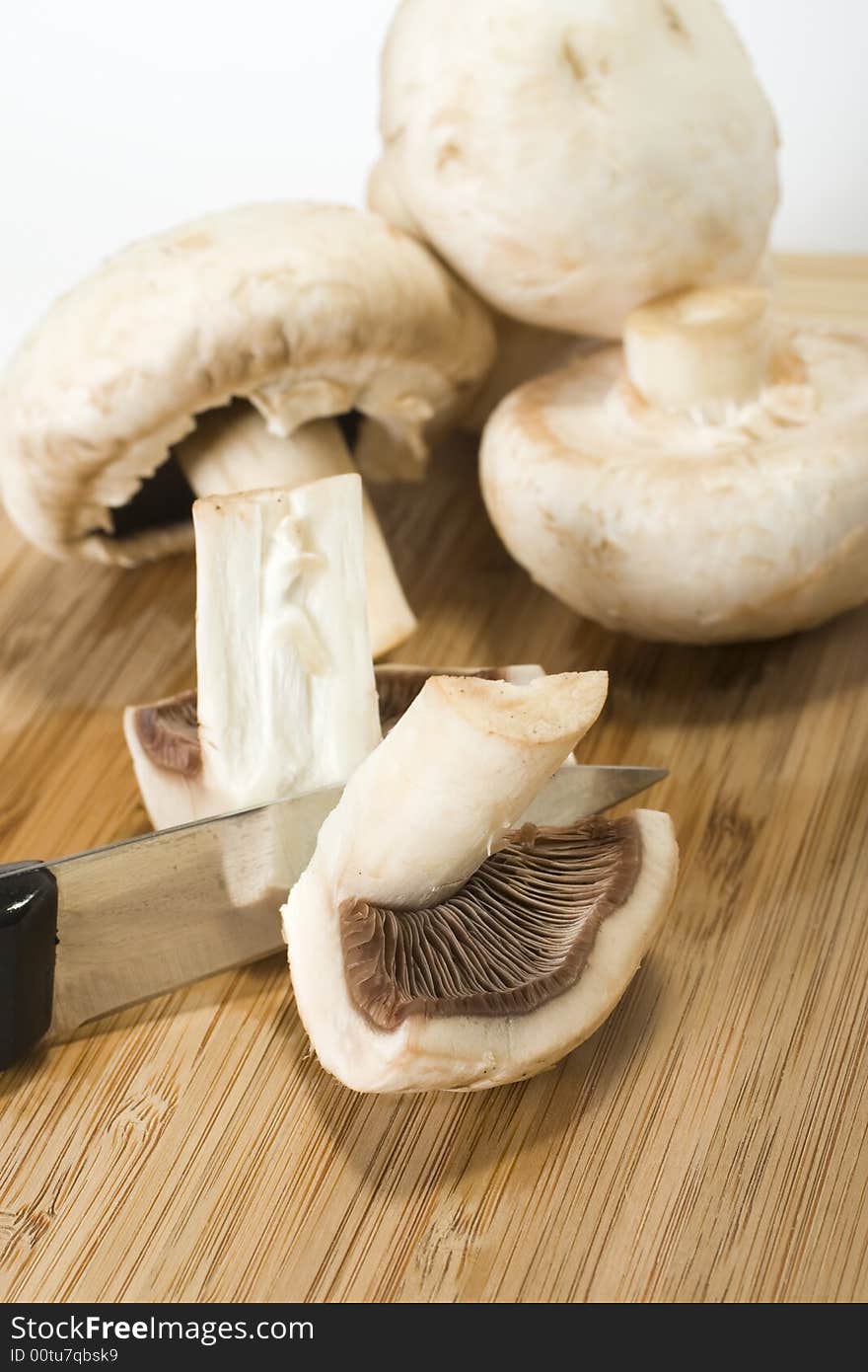 Fresh mushrooms and a knife on wood