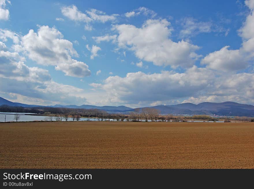 A landscape with a lake under mountains. A landscape with a lake under mountains