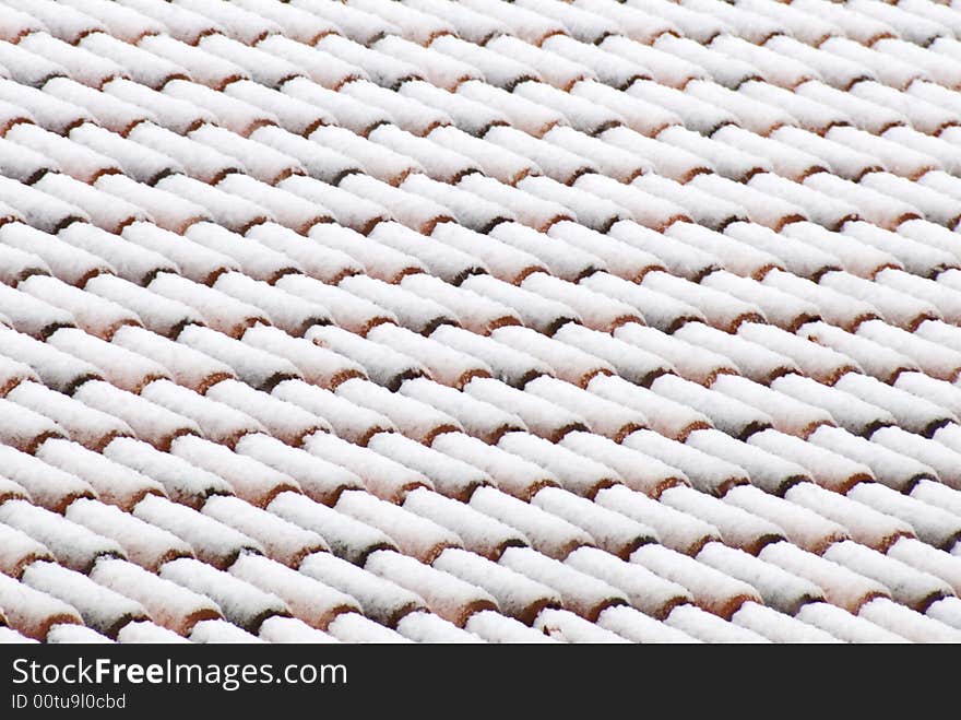 A view of a italian roof tiles under a blanket of snow. A view of a italian roof tiles under a blanket of snow