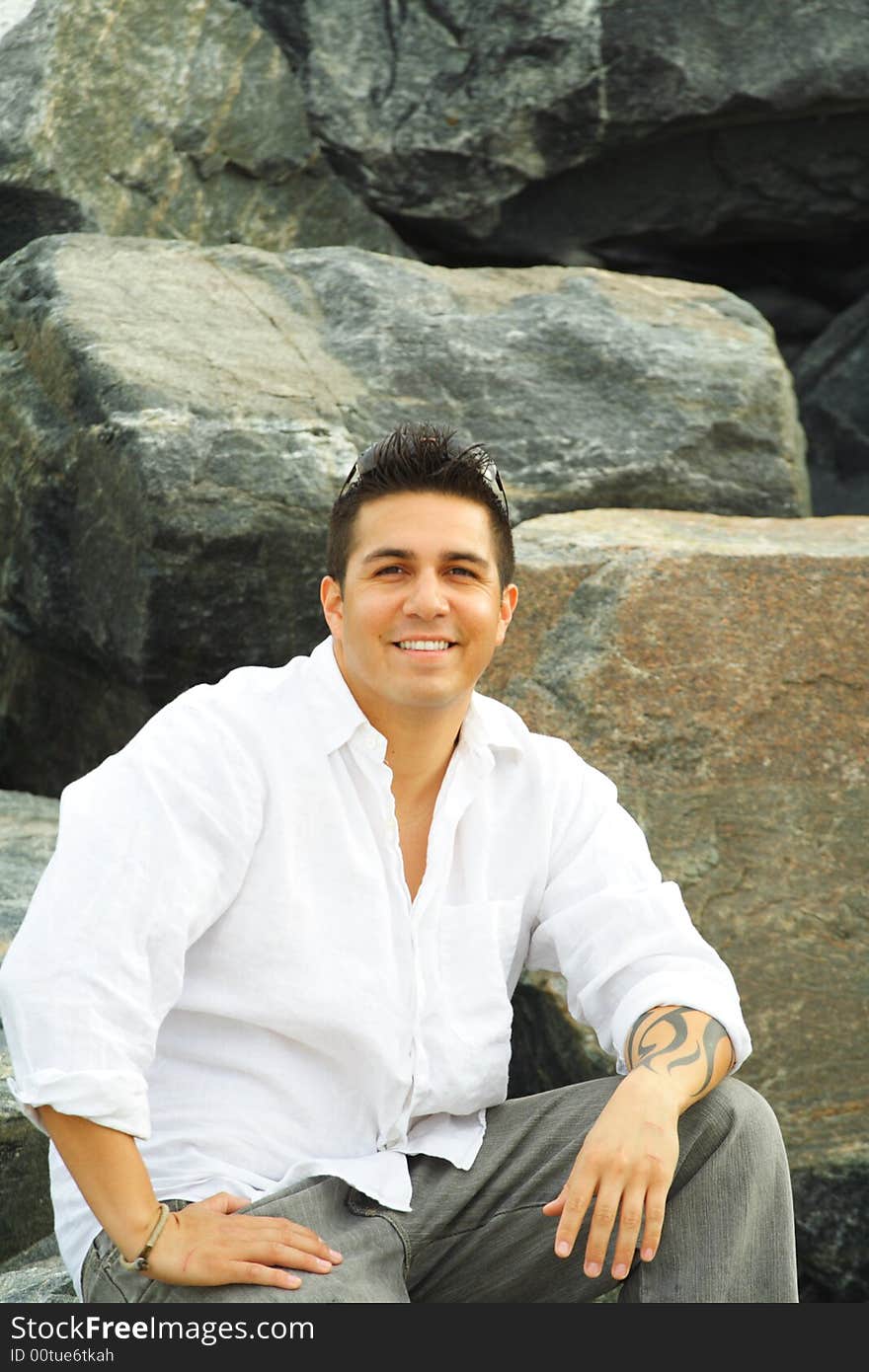 Man sitting on a rock with rocks as a background. Man sitting on a rock with rocks as a background