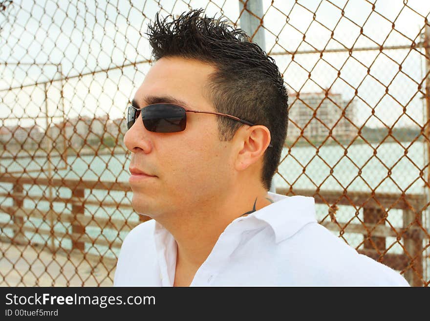 Headshot of a man standing by a fence. Headshot of a man standing by a fence