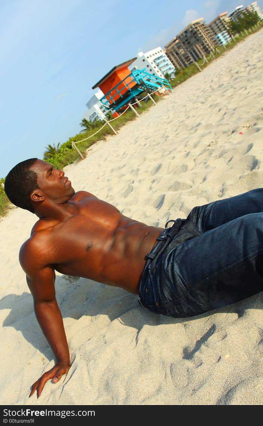 Attractive young Man sitting on the sand. Attractive young Man sitting on the sand