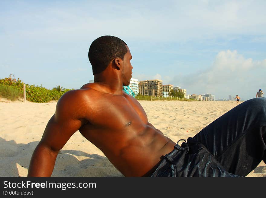 Attractive young Man sitting on the sand. Attractive young Man sitting on the sand