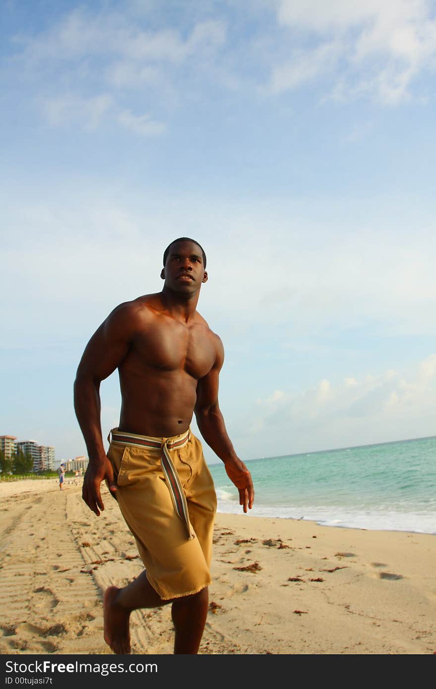 Athletic young man running on the beach