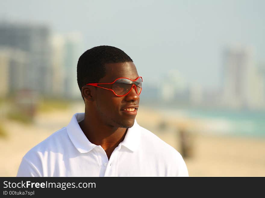 Man on the beach waring red sunglasses. Man on the beach waring red sunglasses.