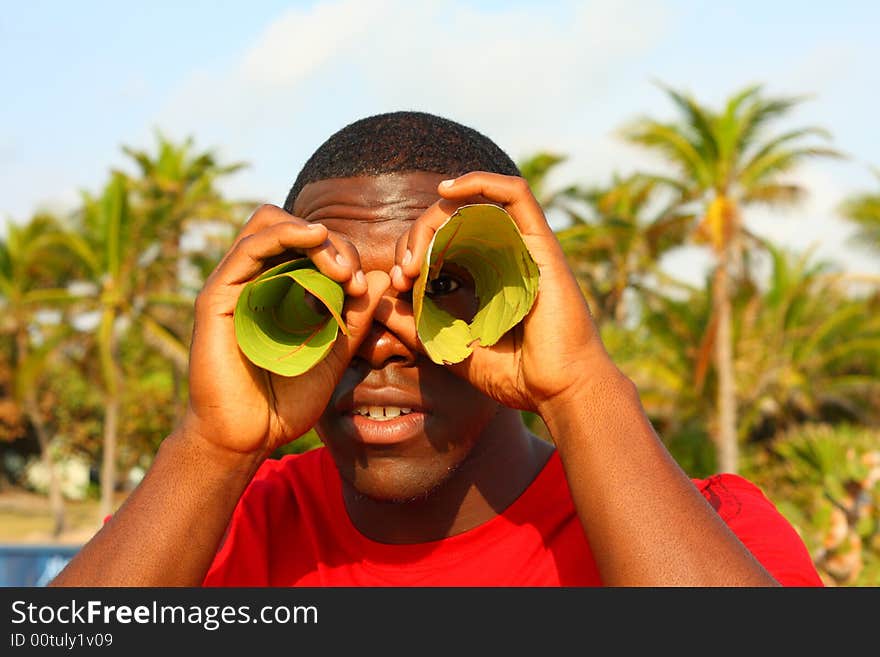 Man looking through leaves as if they were binoculars.