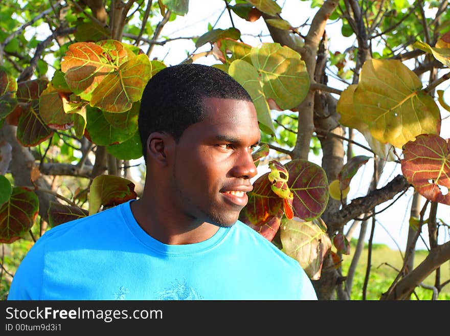 Man with green trees behind him