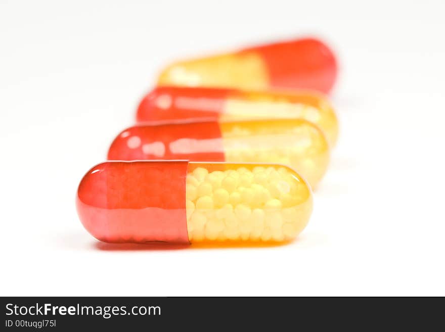 Read and yellow antibiotic pills on white background. Read and yellow antibiotic pills on white background