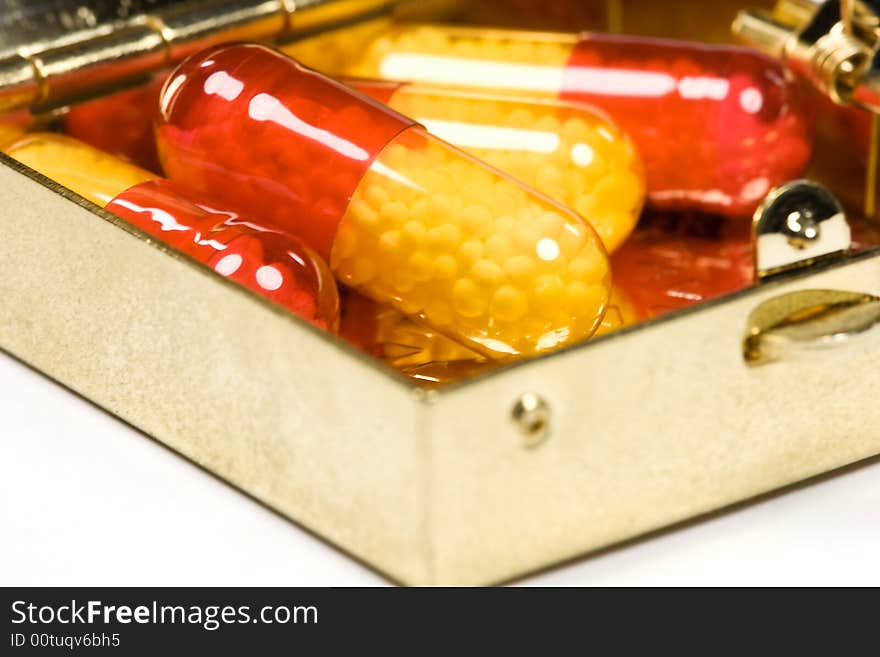 Red and yellow pills in metal container box. Red and yellow pills in metal container box