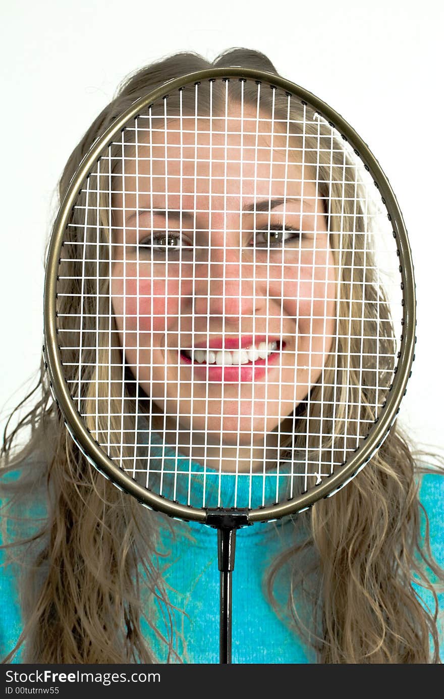 Young lady smiling behind a racket. Young lady smiling behind a racket