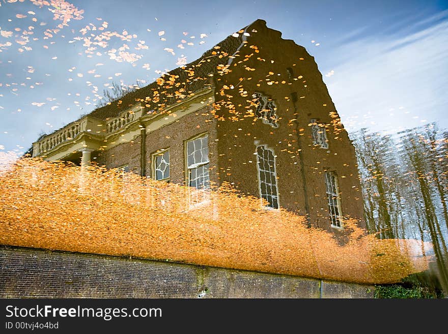 Reflection of a building with leaves in the water. Reflection of a building with leaves in the water