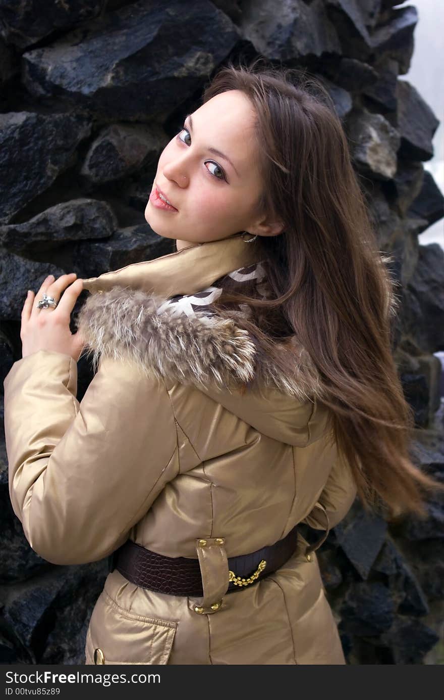 The beautiful young girl on a background of stones