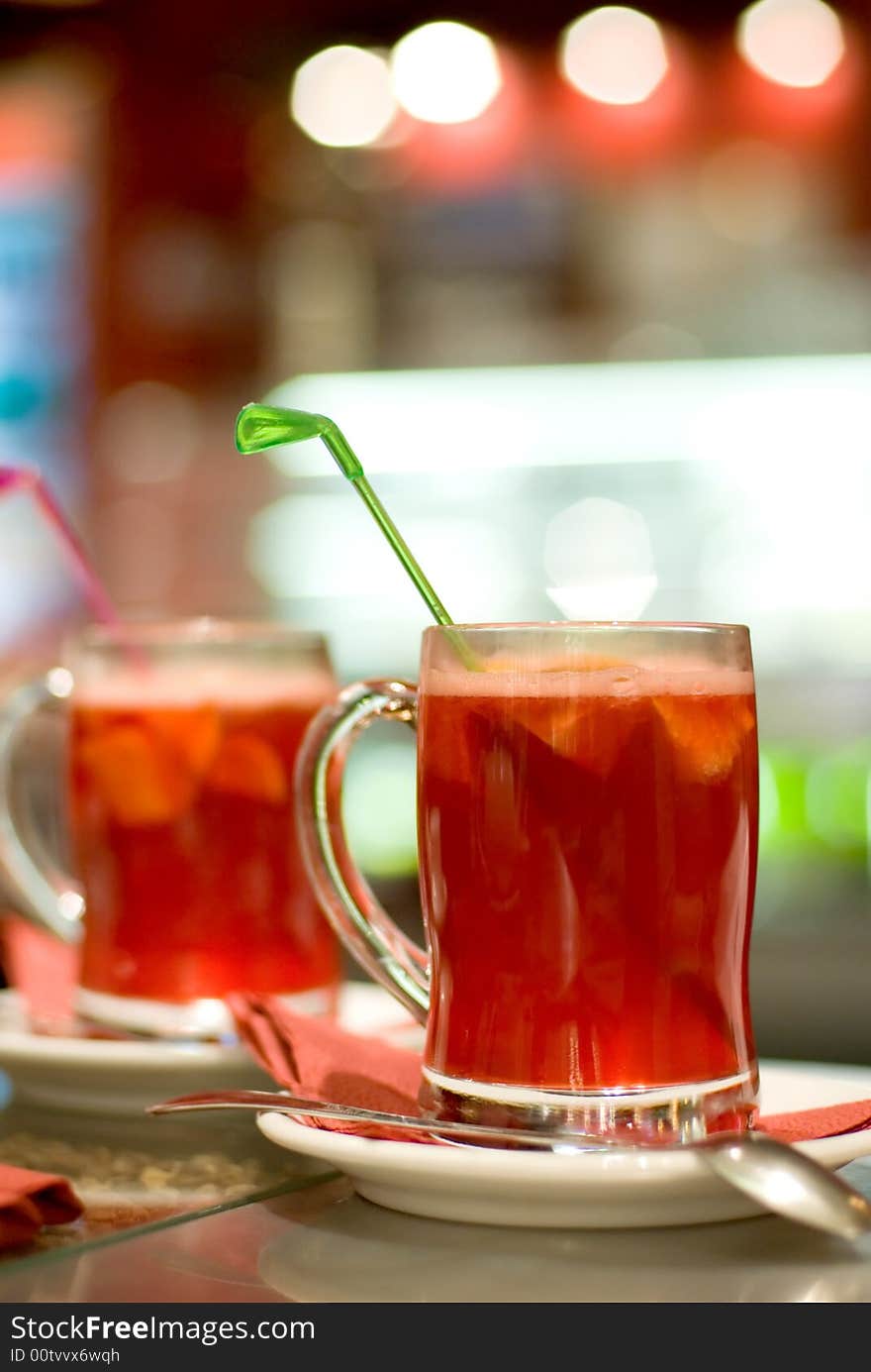 Cup of fruit tea on abstract blurred background (shallow DoF)