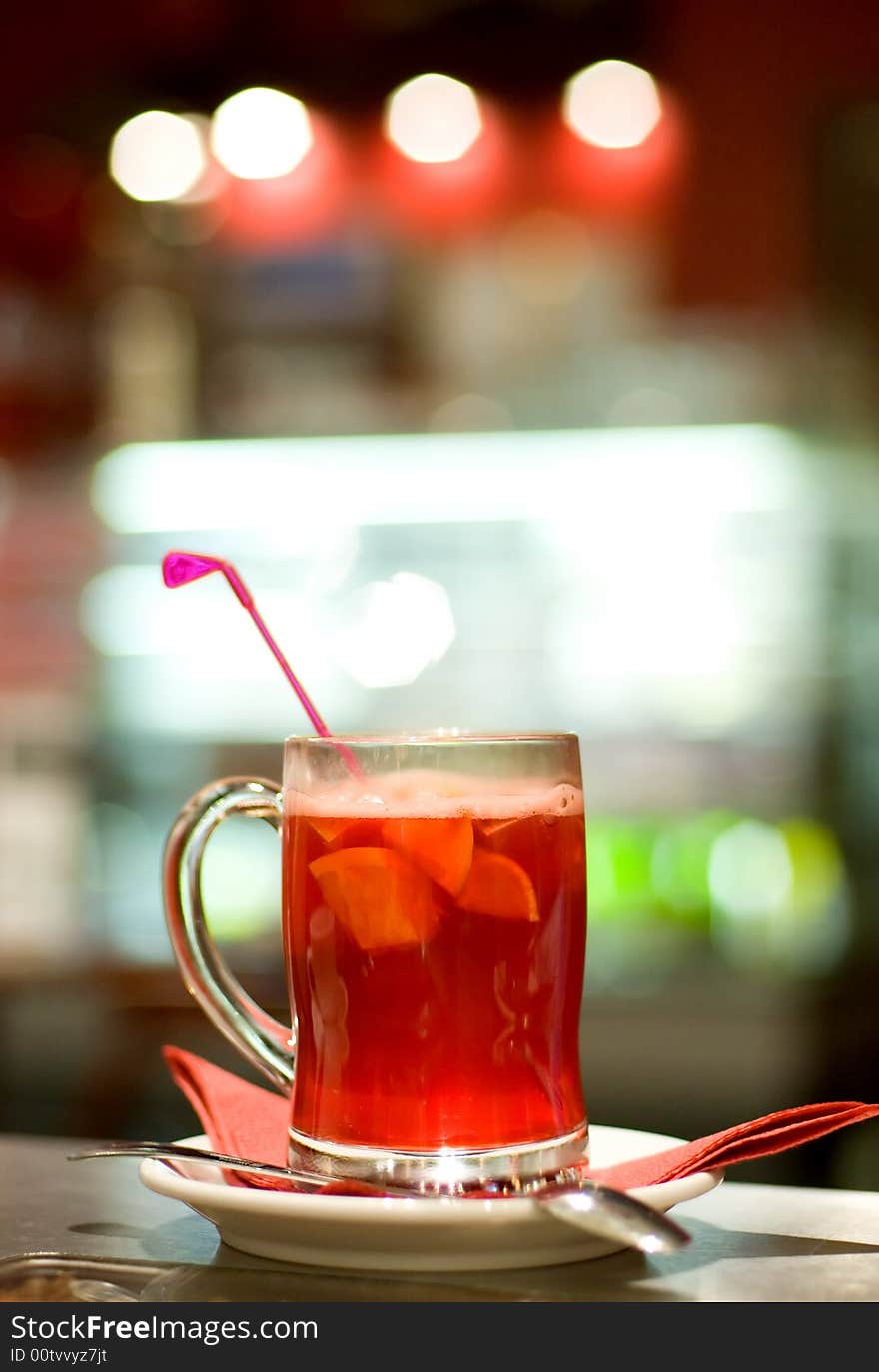 Cup of fruit tea on abstract blurred background (shallow DoF)