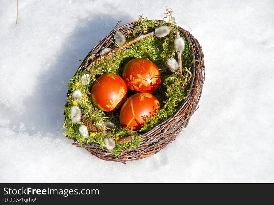 White snow and Easter Eggs in the basket. White snow and Easter Eggs in the basket