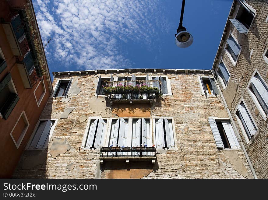 An upward view of a venetian building on a sunny afternoon.