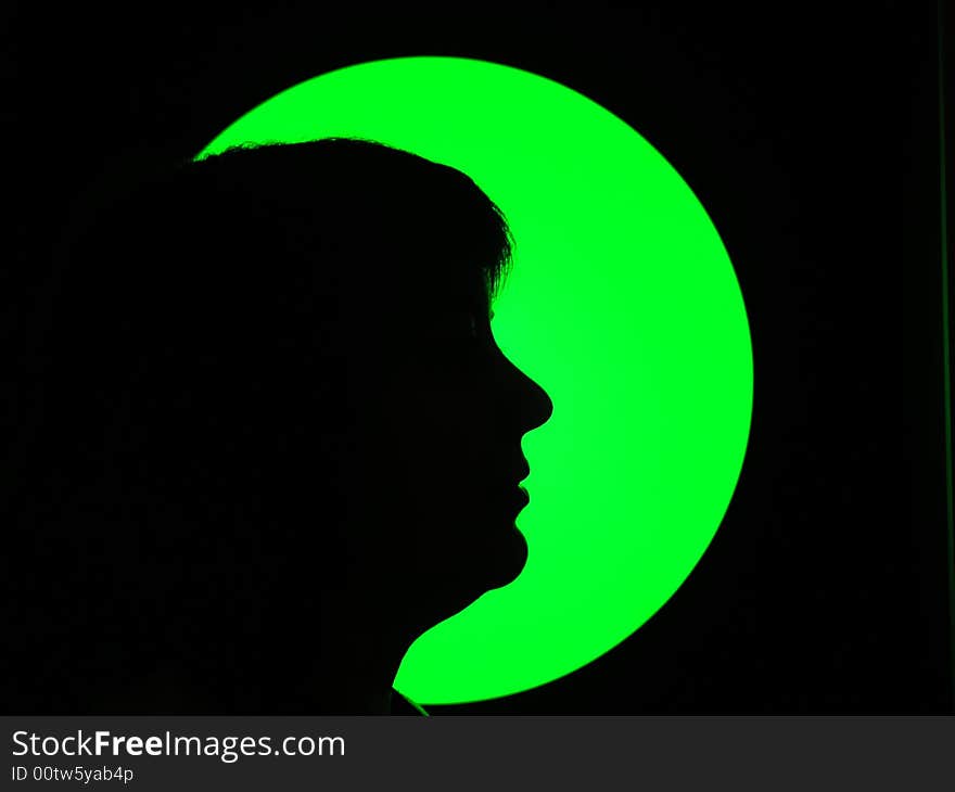 Silhouette of woman in green light and black background