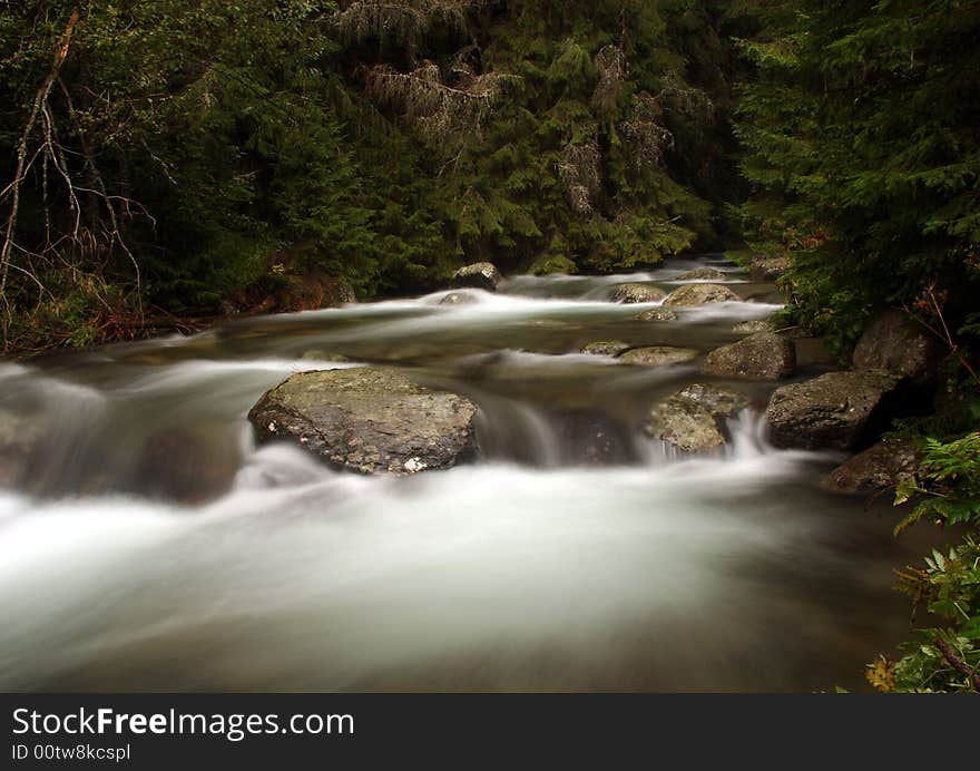 The water of a torrent flow between mountain rocks. The water of a torrent flow between mountain rocks