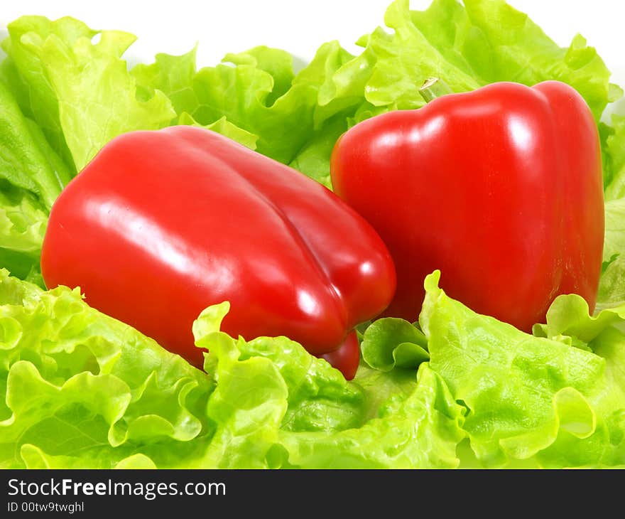 Red pepper and green leaves of salad isolated on a white background