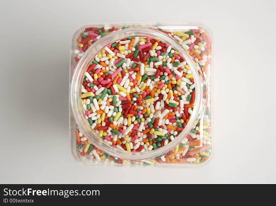 Overhead image of an opened plastic sprinkles jar. Overhead image of an opened plastic sprinkles jar.