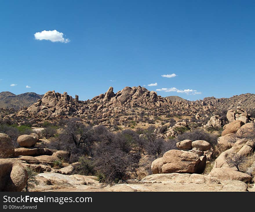 A landscape shot of the desert, with rocks, blue sky, and clouds. A landscape shot of the desert, with rocks, blue sky, and clouds.