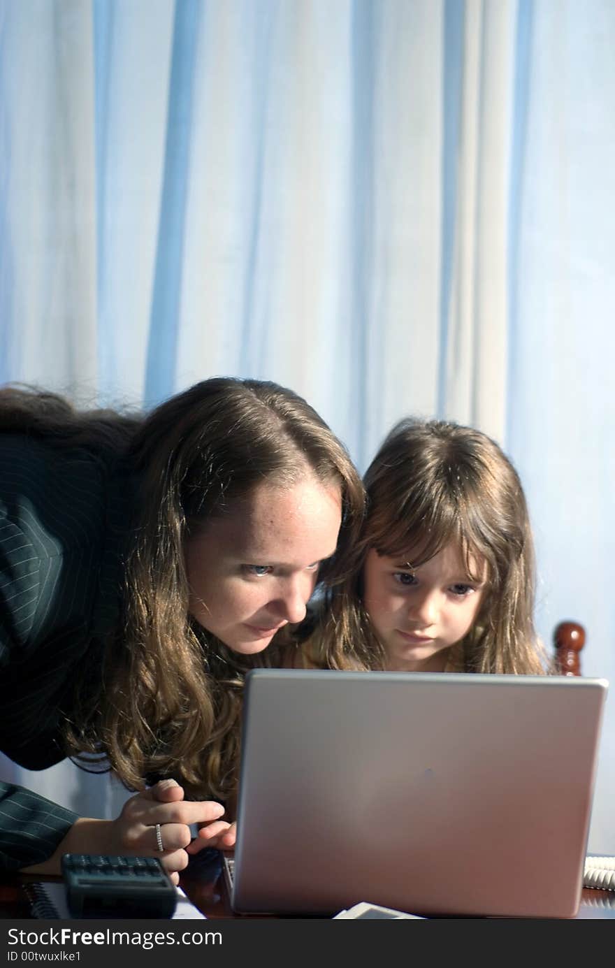 Mother and daughter looking at something on a laptop together