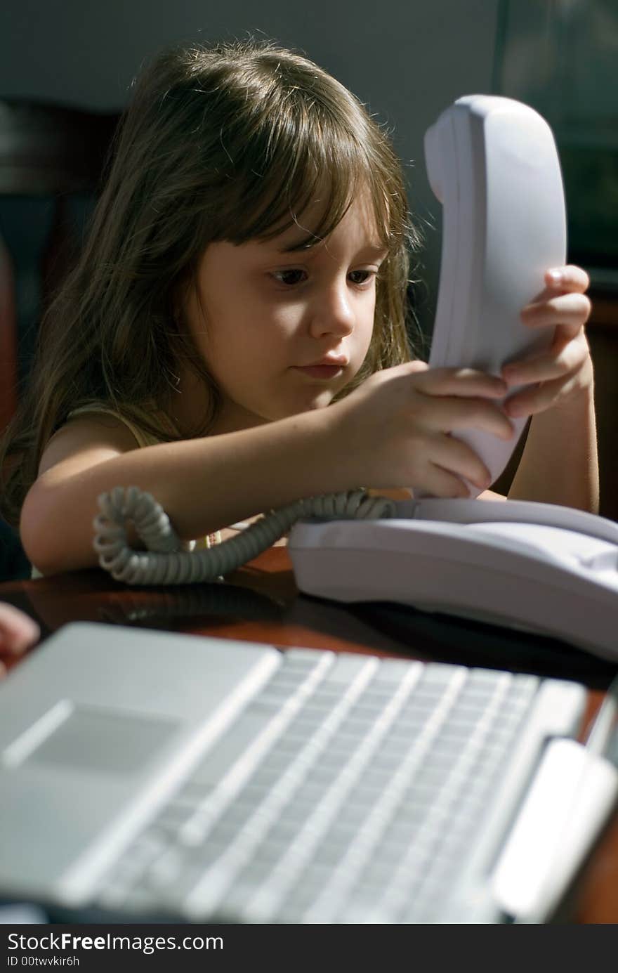 Young girl on the phone in a home office. Young girl on the phone in a home office