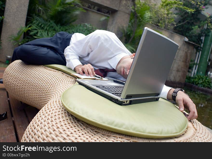 Male in business attire sprawled out in front of his laptop. Male in business attire sprawled out in front of his laptop