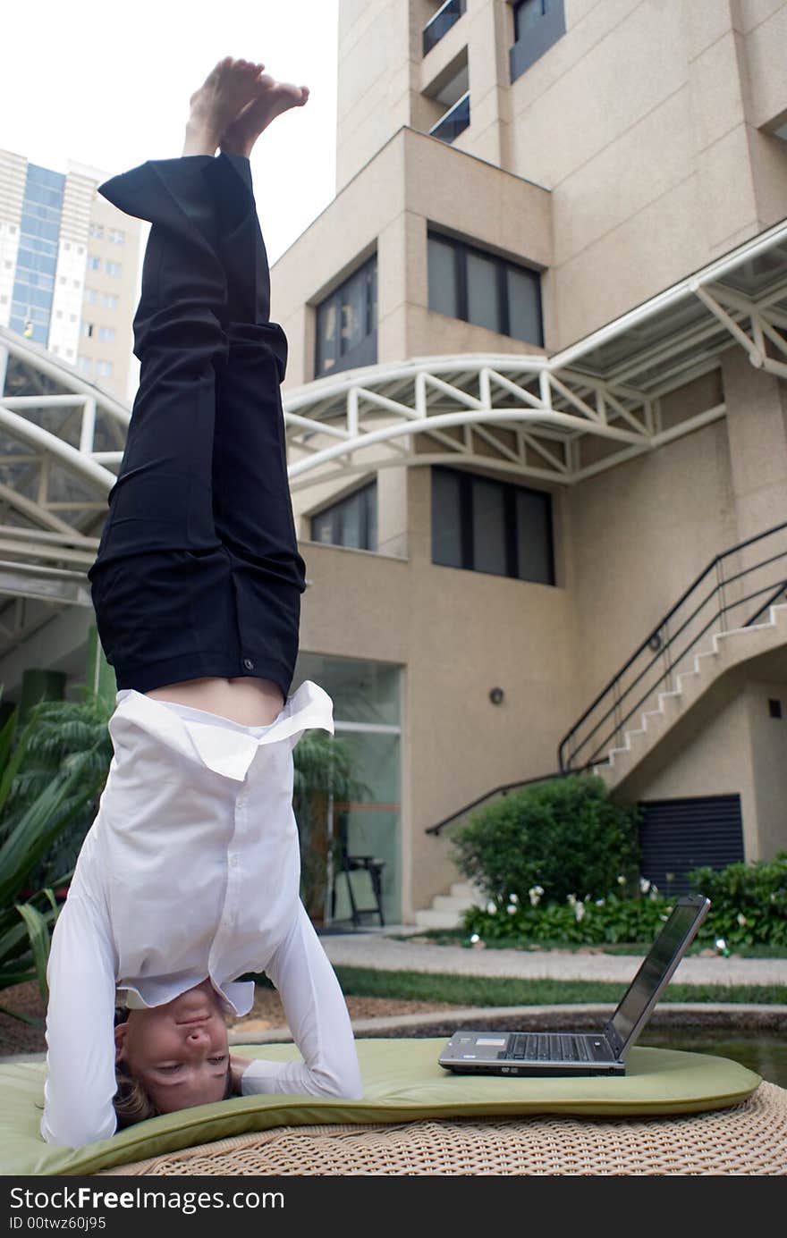 Woman in business attire doing a headstand to clear her head. Woman in business attire doing a headstand to clear her head