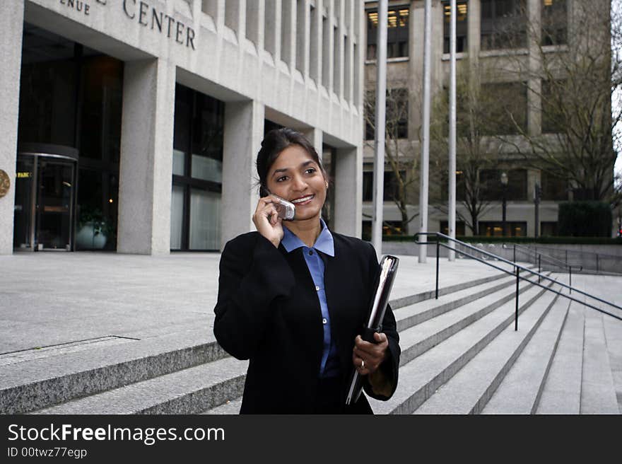 Exceutive Indian woman talking on a cellphone dressed in a black suit. Exceutive Indian woman talking on a cellphone dressed in a black suit.