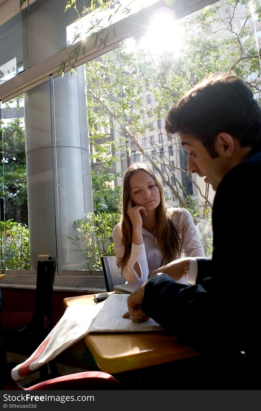 Male and female colleagues  reviewing an article in the paper together. Male and female colleagues  reviewing an article in the paper together