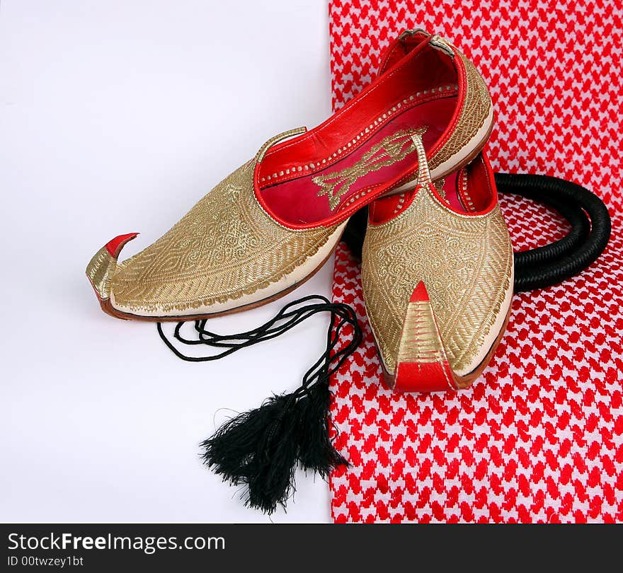 Arabic slippers on white and red background.