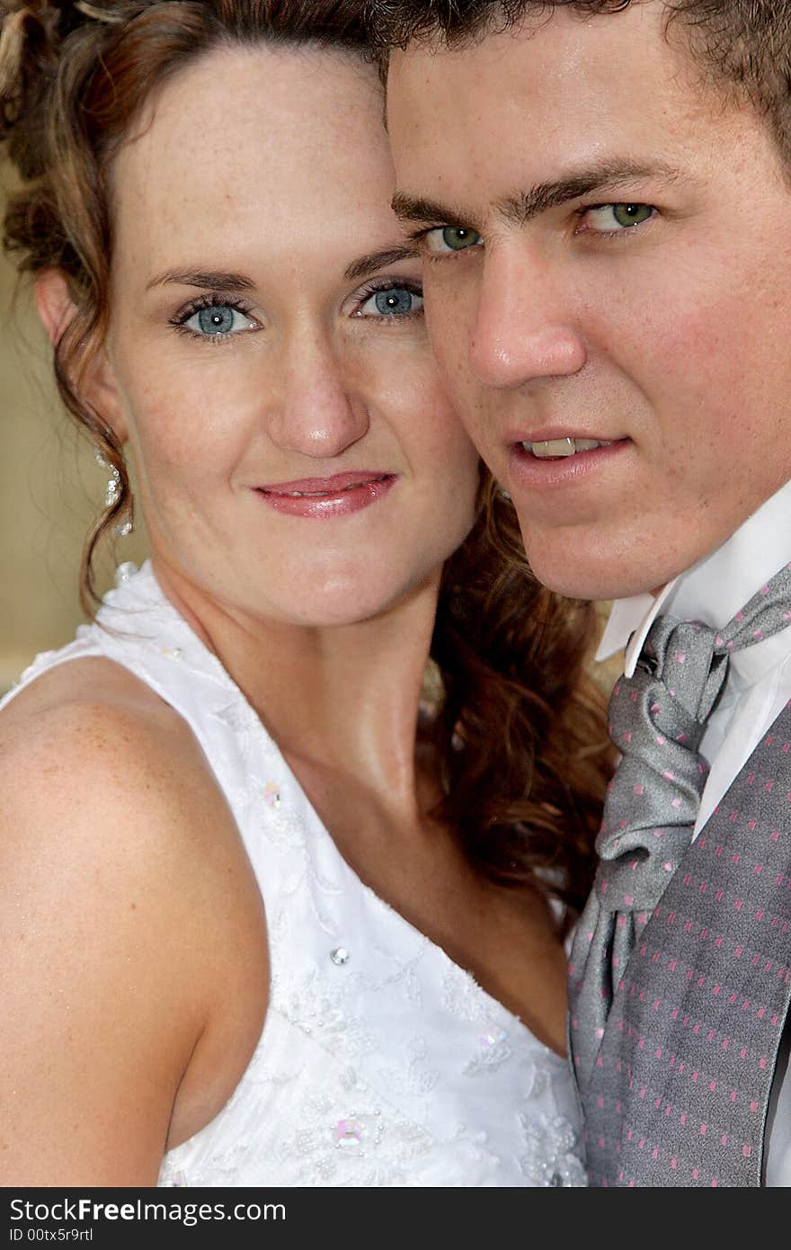 A portrait of a bride and groom standing close. A portrait of a bride and groom standing close