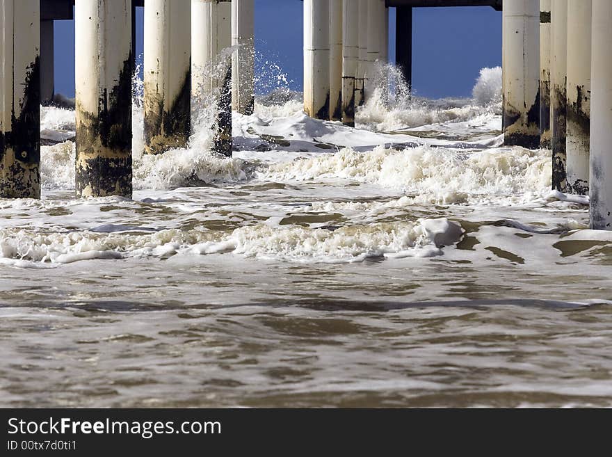 White waves breaking on concrete pillars