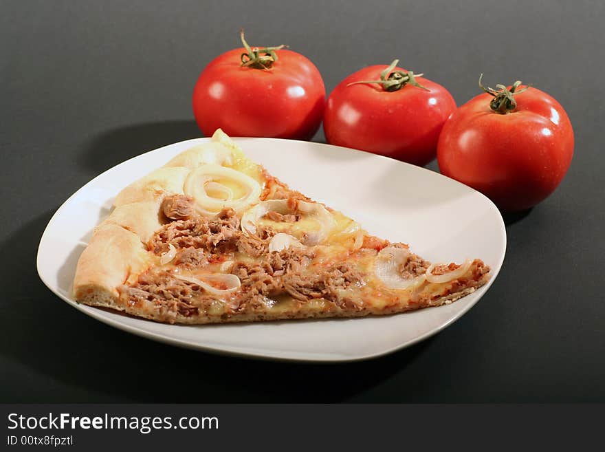 Pizza with tomatoes on a black background.