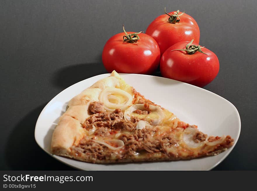 Pizza with tomatoes on a black background.