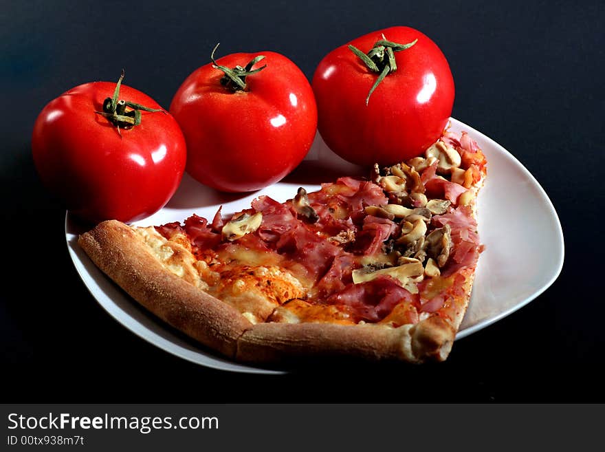 Pizza with tomatoes on a black background.