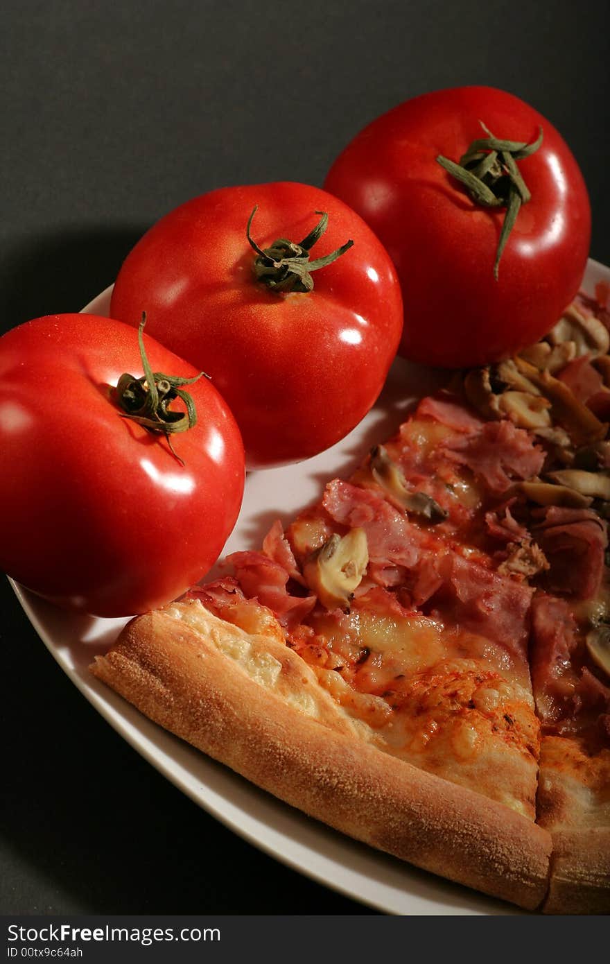 Pizza with tomatoes on a black background.